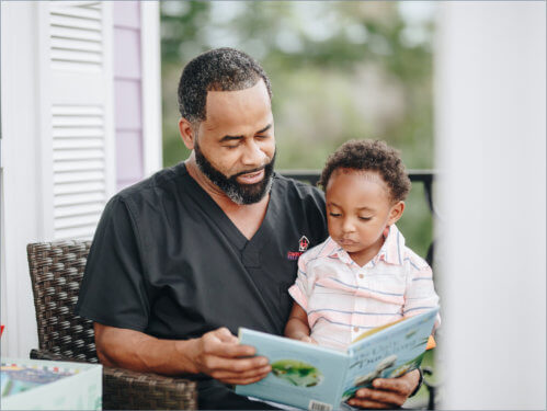 adult man and a child reading a book